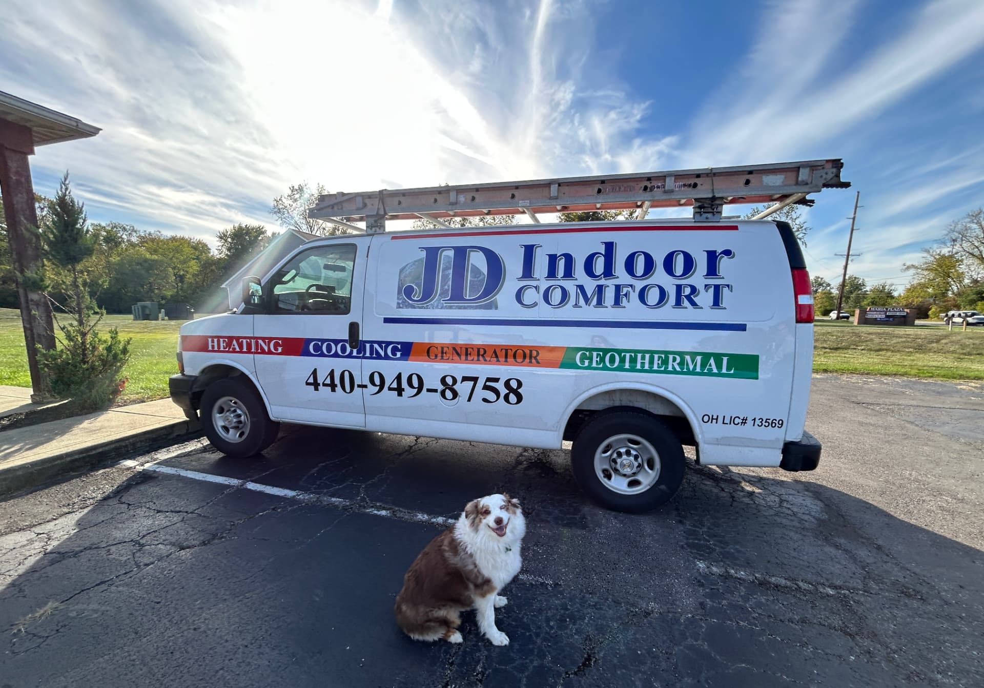JD Indoor Comfort service van parked on a sunny Northeast Ohio street with the company mascot dog