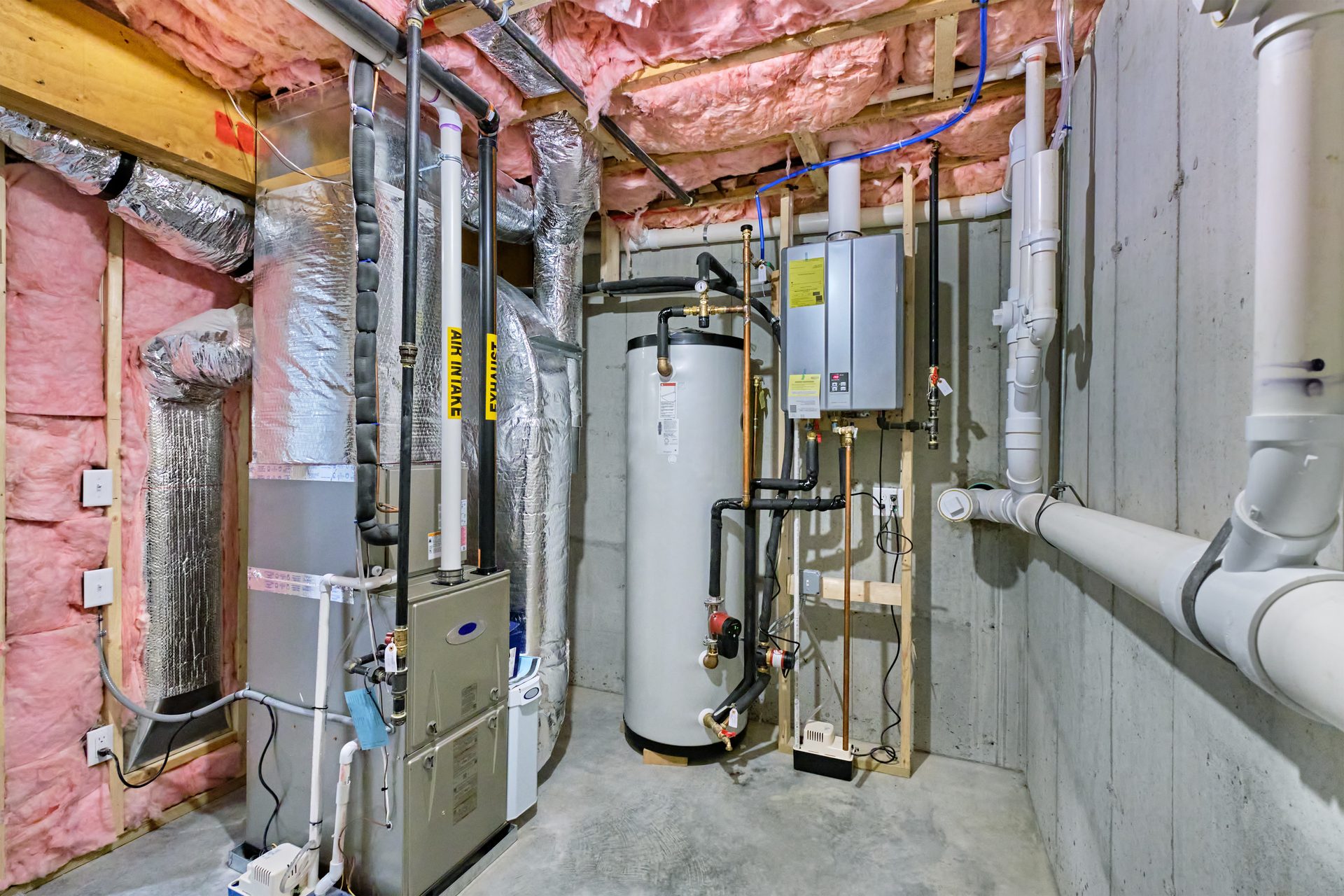 High-efficiency furnace, water heater, and tankless unit installed in a clean Northeast Ohio basement mechanical room