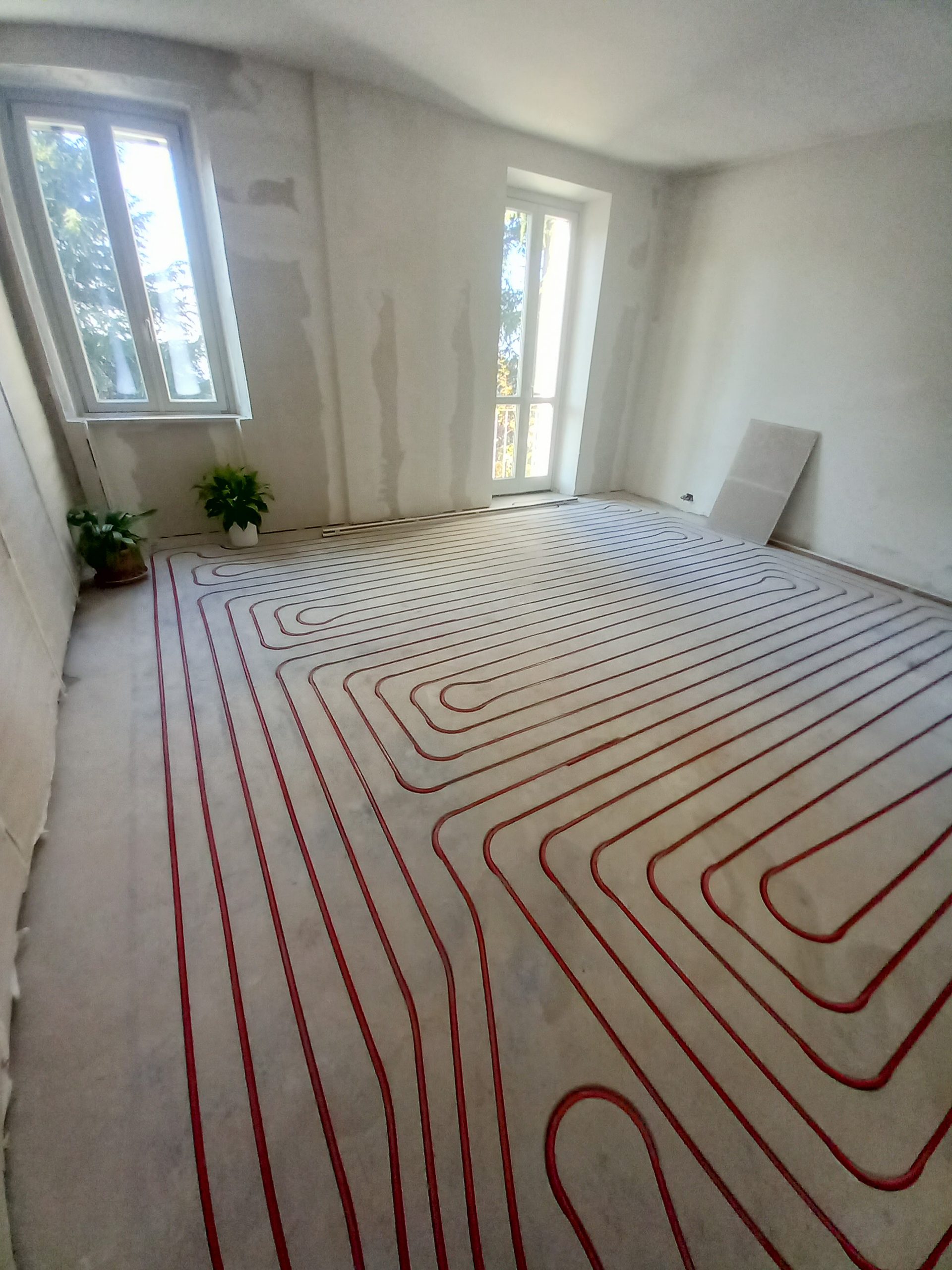 Radiant floor heating tubing looped across a subfloor before the finish floor is poured
